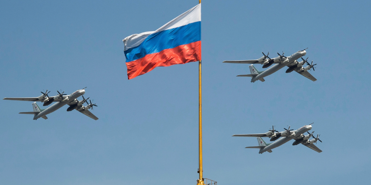 Ryska strategiska bombflygplan av typen Tu-95 flyger förbi en rysk flagga vid Kremlområdet under en repetition inför militärparaden på segerdagen i Moskva, Ryssland, den 4 maj 2018.