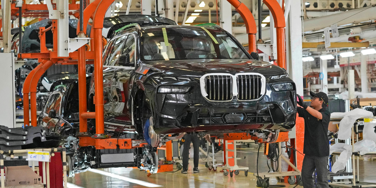 En halvbyggd BMW hänger i produktionshallen.