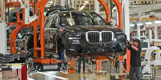 En halvbyggd BMW hänger i produktionshallen.