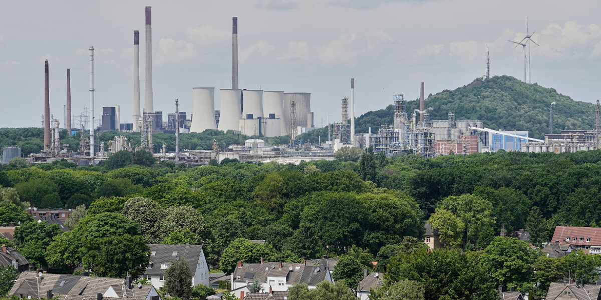 Ett kolkraftverk som tillhör Uniper och en kemisk fabrik och ett raffinaderi som tillhör BP syns bakom bostadshus i Gelsenkirchen, Tyskland, onsdagen den 21 maj 2025. (Foto: Martin Meissner / TT)