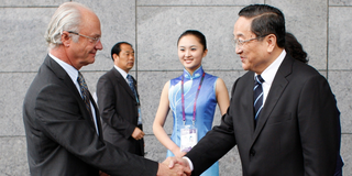 Sveriges kung Carl XVI Gustaf, till vänster, och Shanghais kommunistpartisekreterare Yu Zhengsheng, till höger, skakar hand i samband med invigningen av Sveriges paviljondag, den 23 maj 2010 i Shanghai, Kina. (Foto: Eugene Hoshiko / TT)