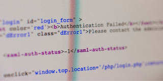 Detaljbild av datorns källkod som visas på en skärm, som visar element av webbutveckling.