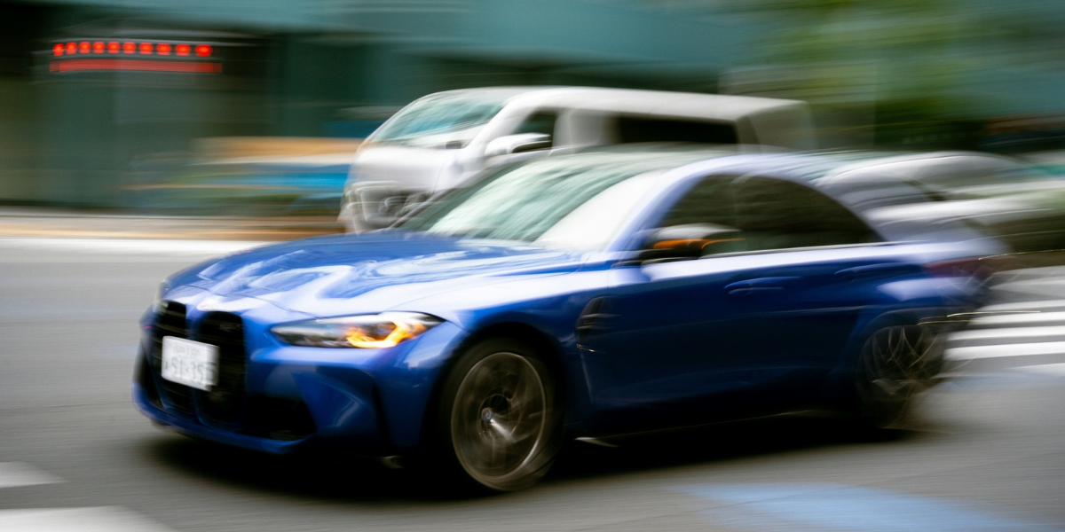 En blå BMW swishar förbi.