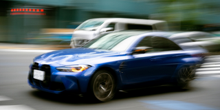 En blå BMW swishar förbi.